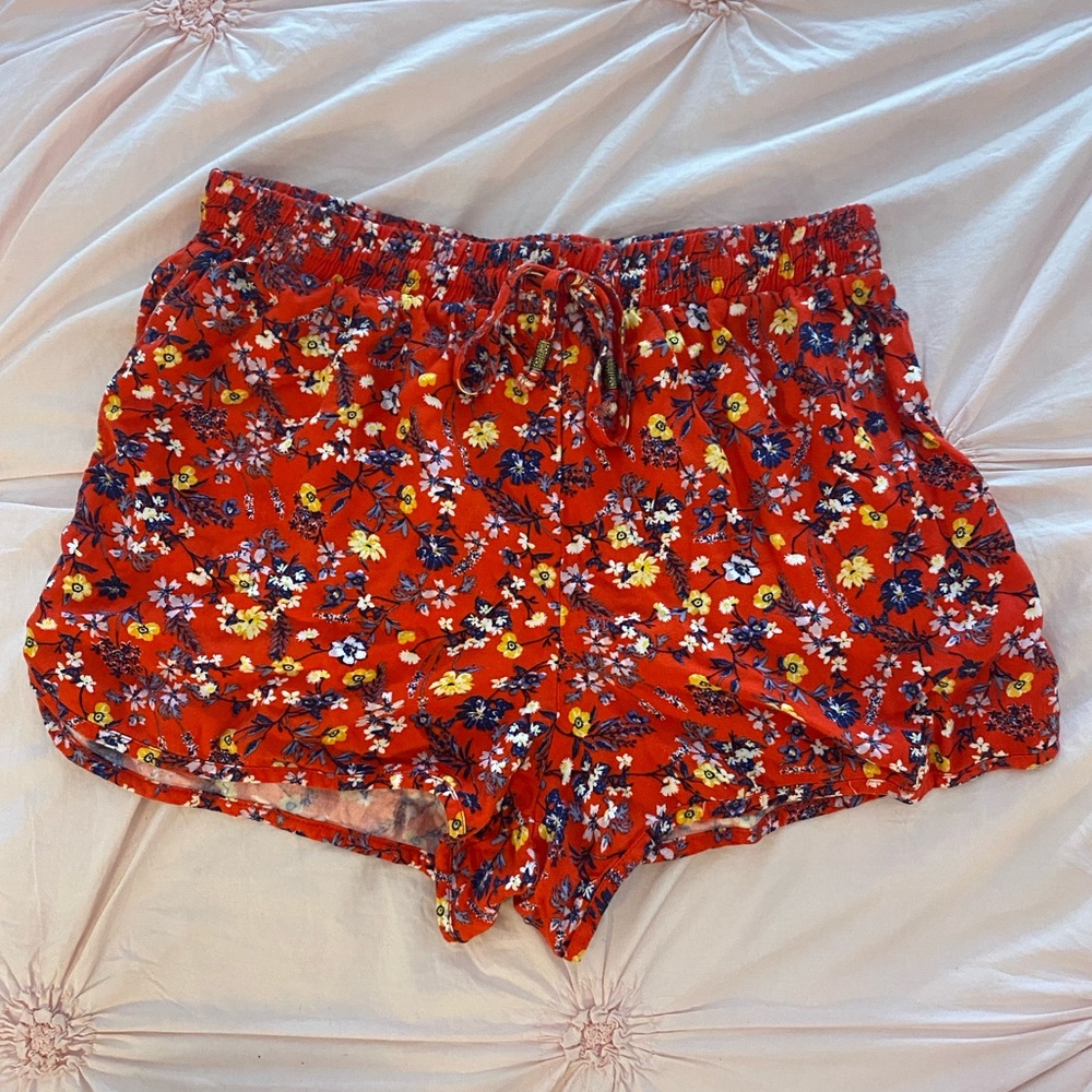 Red elastic shorts with floral print.